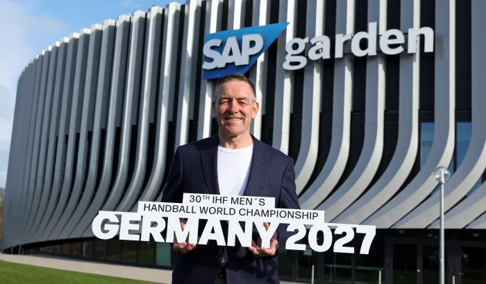 Alfred Gislason mit Schriftzug in der Hand draußen vor den SAP Garden.