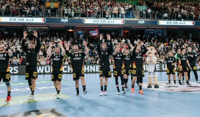 Handball-Männer-Nationalmannschaft jubelt nach Spiel zu Fans.