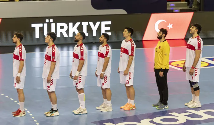 Türkische Handball-Nationalmannschaft singt die Hymne vor einem Handballspiel.