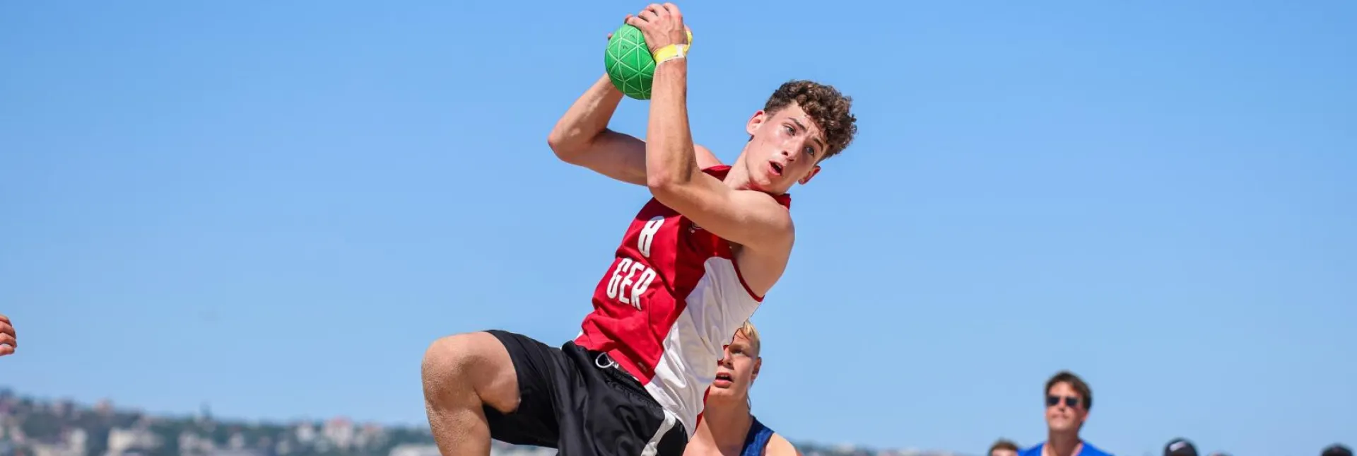 Beachhandballer setzt zum Wurf an