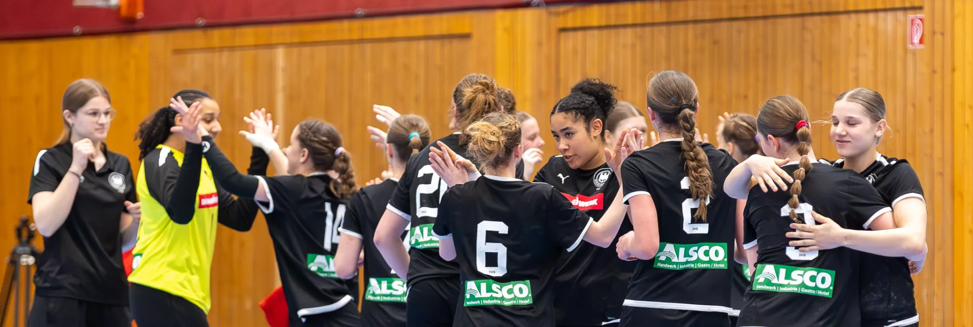 Eine Handballmannschaft die sich nach dem Spiel abklatscht 