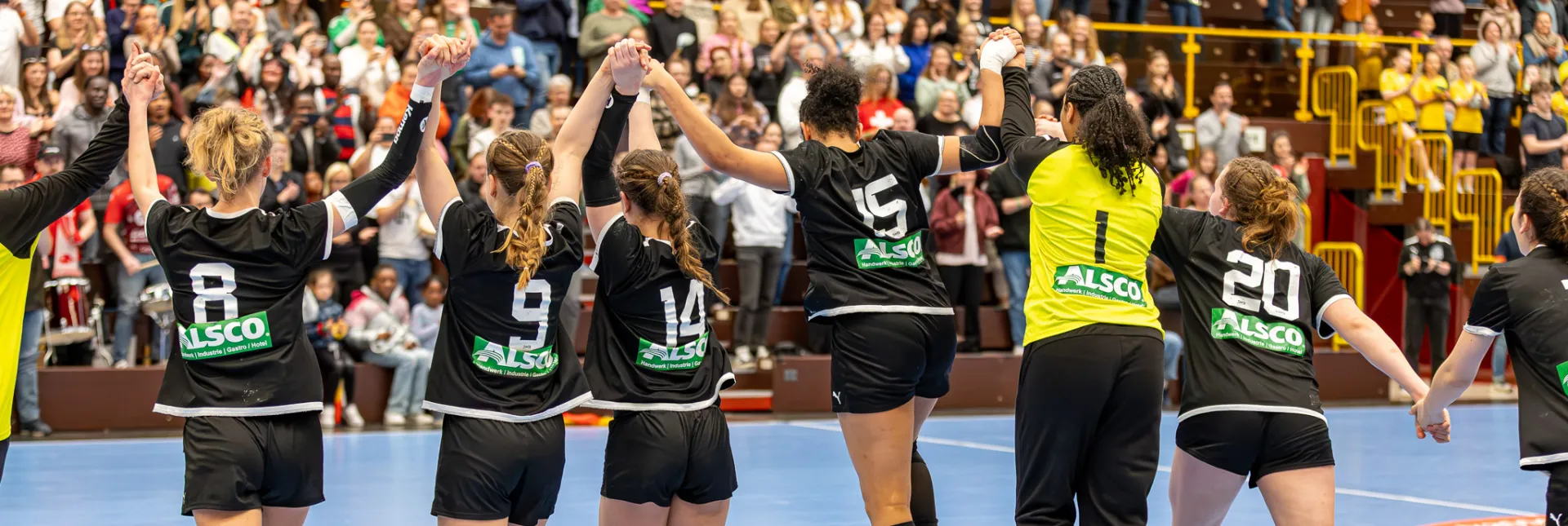 Eine Truppe jubelnder Spielerinnen die ihre Hände in die Luft strecken