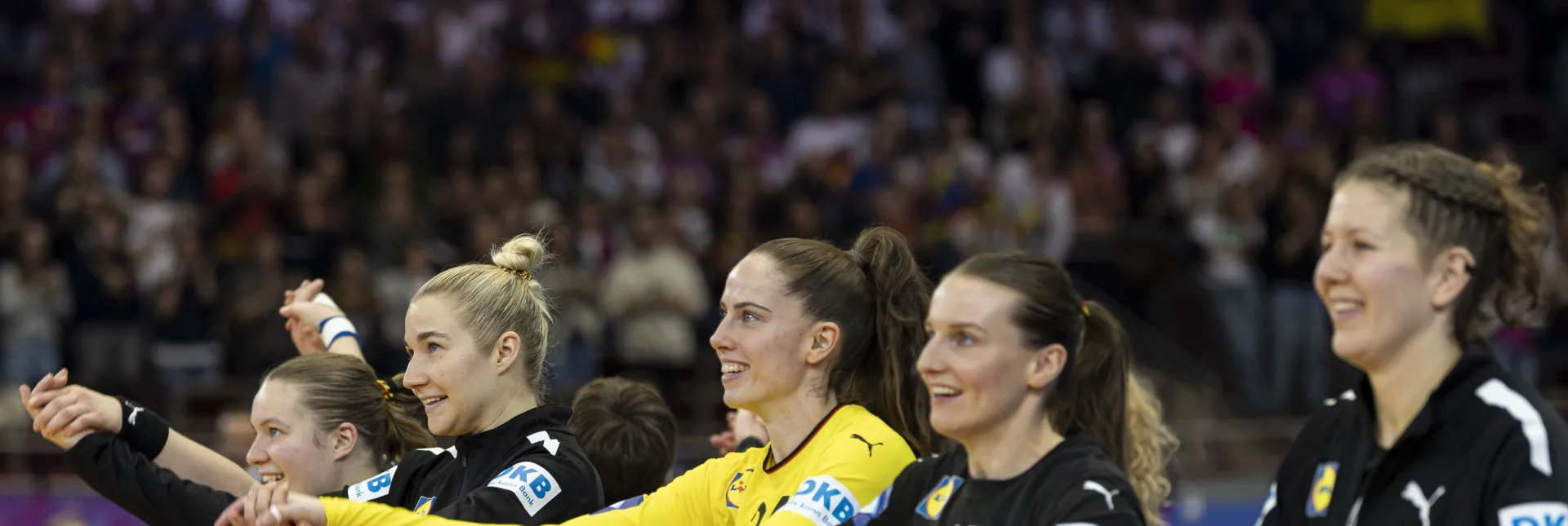 Eine Truppe Frauen die zusammen jubeln und die Hände in die Luft strecken. 