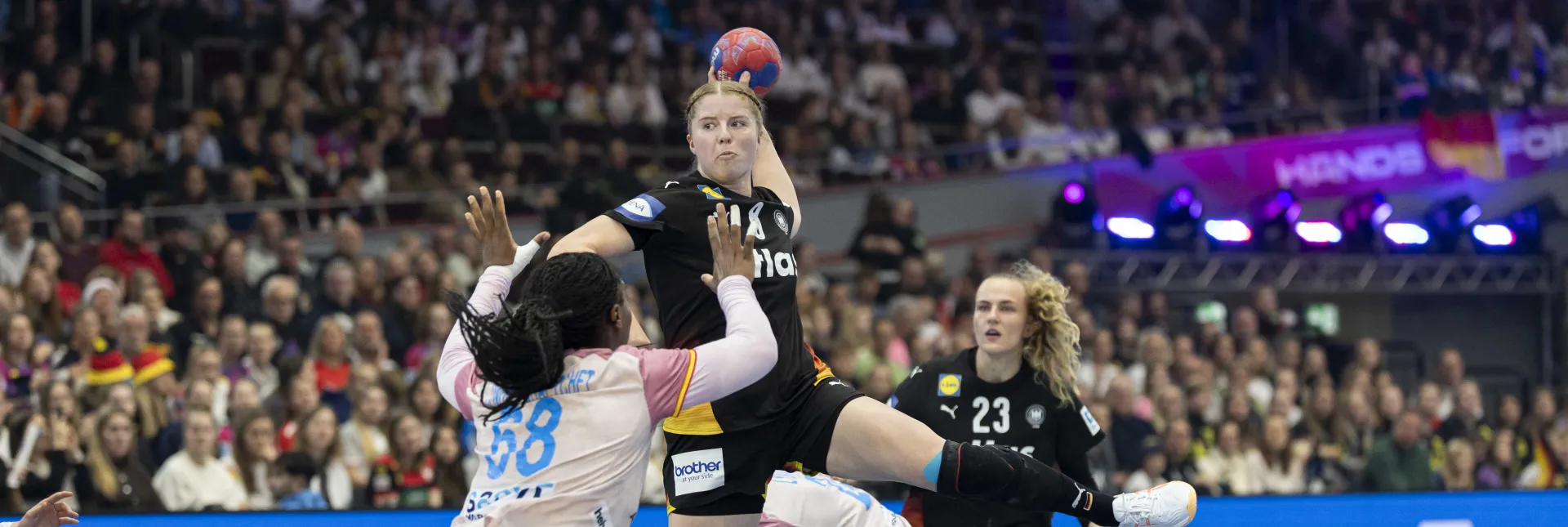 Eine Handballspielerin beim Sprungwurf auf das Tor. 