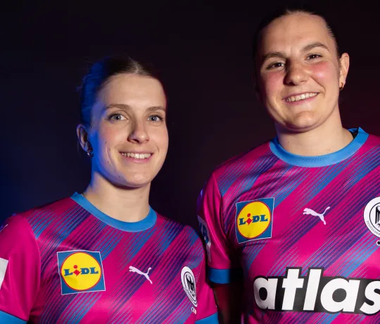 Zwei DHB-Spielerinnen im magentafarbenen Sondertrikot der Nationalmannschaft.
