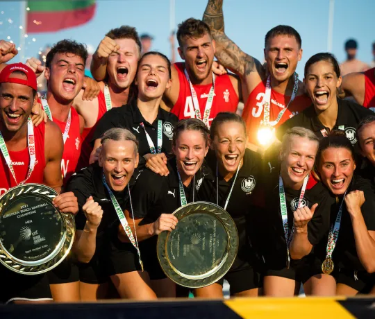 Eine Truppe von Handballerinnen und Handballern die zusammen jubeln. 