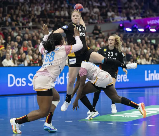 Eine Handballspielerin die auf das Tor wirft.