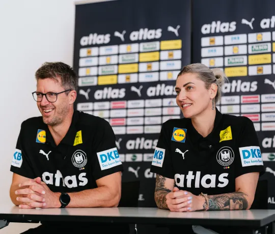 Ein Mann und eine Frau die nebeneinander sitzen und Lachen. 