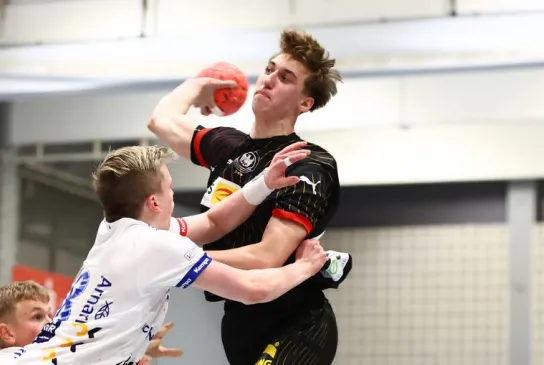 U18 Nationalspieler wird beim Rückraumwurf bedrängt.