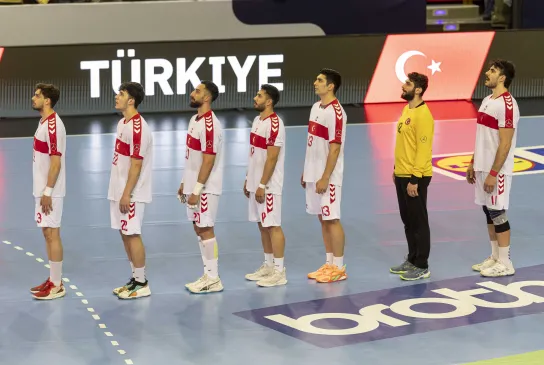 Türkische Handball-Nationalmannschaft singt die Hymne vor einem Handballspiel.