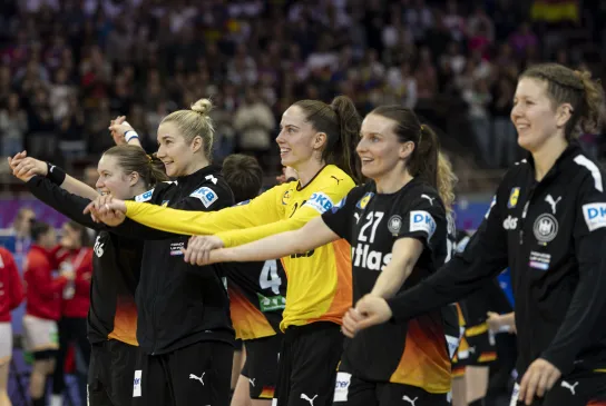 Eine Truppe Frauen die zusammen jubeln und die Hände in die Luft strecken. 