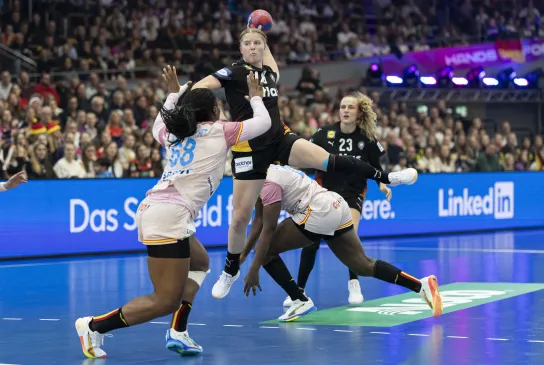 Eine Handballspielerin beim Sprungwurf auf das Tor. 