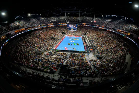Blick von oben in den gefüllten Innenraum der Lanxess arena bei einem Handballspiel.